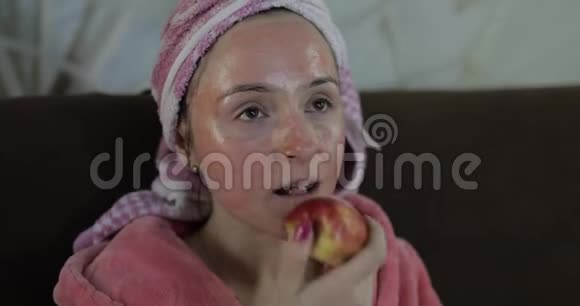 女人在电视上看深夜电影吃苹果浴衣面膜视频的预览图