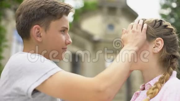 温柔的男朋友轻轻地抚摸着女朋友的脸情侣们互相看着对方视频的预览图