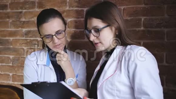 两位女医生一起站在医院讨论视频的预览图