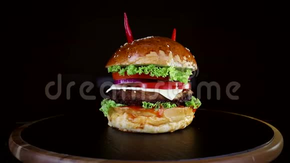 快餐红椒汉堡在黑色背景的木板上慢慢旋转视频的预览图