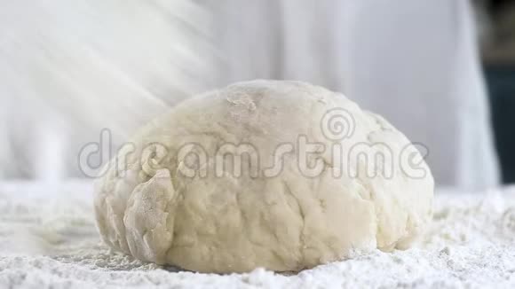 专业面包师把白小麦粉撒在生面团上厨房准备面包关门视频的预览图