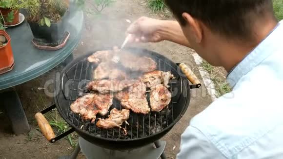 人翻来覆去的大块美味的肉牛排在烧烤炉上烤过煤视频的预览图