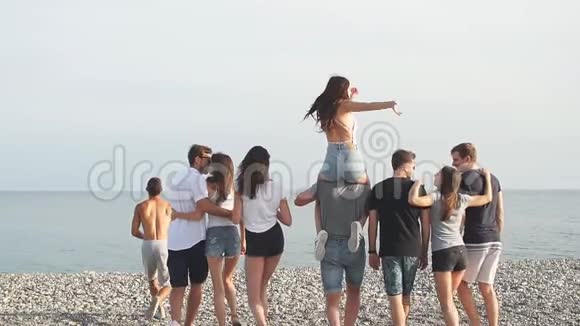 快乐的朋友在海滩上散步到海边玩得开心举起手来视频的预览图