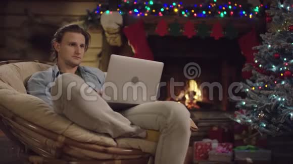 圣诞夜年轻的帅哥在笔记本电脑上发短信视频的预览图