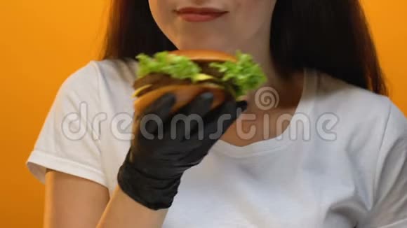 快餐店顾客在镜头前展示汉堡品尝不健康食品视频的预览图
