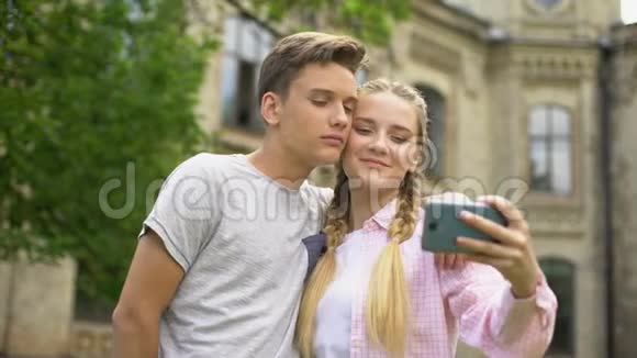 青少年夫妇在观光时使用电话自拍一起摆姿势视频的预览图