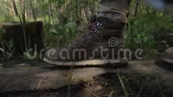 徒步靴子特写人走过森林中一棵倒下的树4K视频的预览图