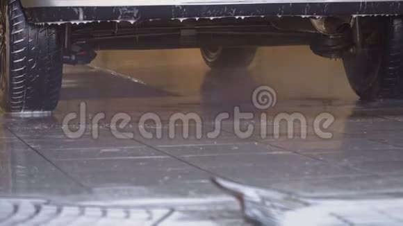 一名工人用泡沫在水压下为汽车清洗垫子视频的预览图