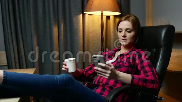 办公室里的年轻女人休息一下在手机上输入信息喝咖啡视频的预览图
