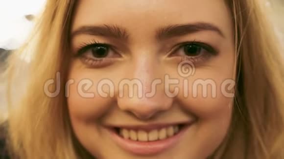 一个棕色眼睛和迷人微笑的顽皮女孩的特写肖像视频的预览图