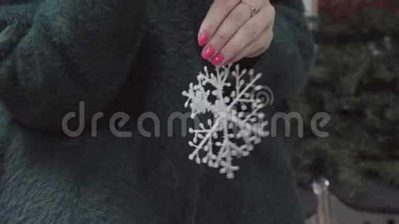 女人手拿着圣诞玩具雪花视频的预览图