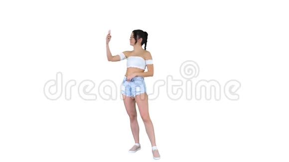 可爱的黑发女孩自拍和跳舞的白色背景视频的预览图