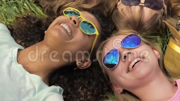 亲密的朋友脸快乐的女孩和男人躺在草地上开玩笑笑视频的预览图