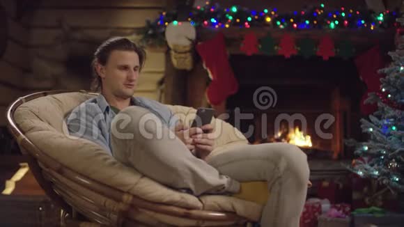 圣诞夜帅哥用智能手机视频聊天视频的预览图