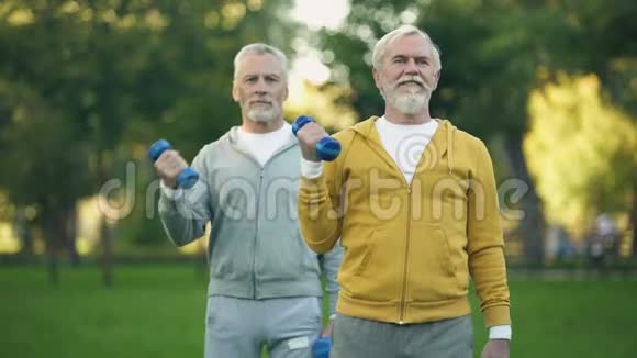 老年人在公园里举起哑铃朋友们一起健身视频的预览图