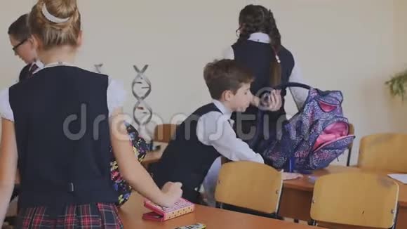 穿着校服的学童戴上背包回家慢动作教室里的高中生视频的预览图