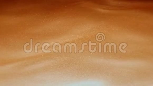 金色的闪亮的抽象的液体状的沙子慢慢地慢慢地向左流动在柔和的波浪中闪闪发光视频的预览图
