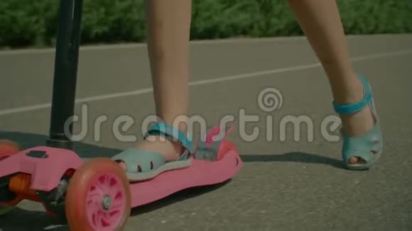 公共公园里骑着推式滑板车的小女孩视频的预览图