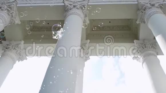 许多肥皂泡在古典廊柱的背景上飞舞视频的预览图
