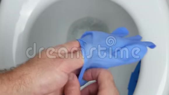 卫生间的男人手里拿着手套准备打扫马桶座视频的预览图