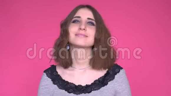 有魅力的女人的肖像她正在发送一个空气吻孤立在明亮的粉红色背景上视频的预览图