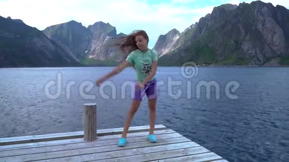 一个女孩在海边的码头上跳舞视频的预览图