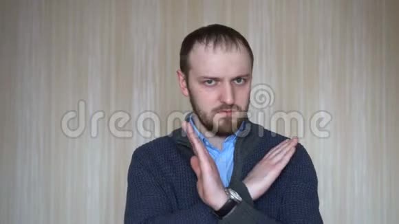 青年男子肖像显示停止标志不喜欢拒绝手势不同意标志交叉手视频的预览图
