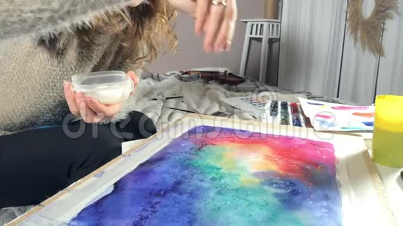 成年女性用彩色水彩颜料和撒盐在艺术学校中产生效果视频的预览图