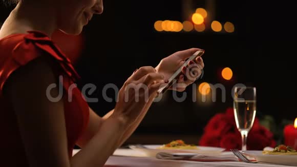诱惑女人在餐厅滚动智能手机应用程序等待人相亲视频的预览图