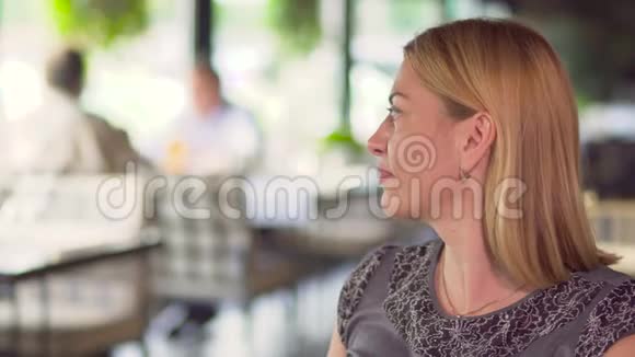 优雅的女人在咖啡馆放松喝咖啡在后台商务会议视频的预览图