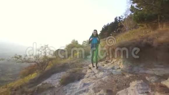 孤独的女游客背着背包在山路上旅行视频的预览图