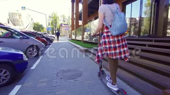 女孩骑着电动滑板车在城市慢莫后景视频的预览图