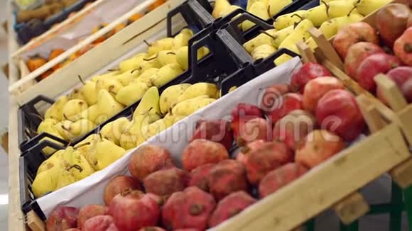 成熟的石榴和梨在超市柜台上的盒子里视频的预览图