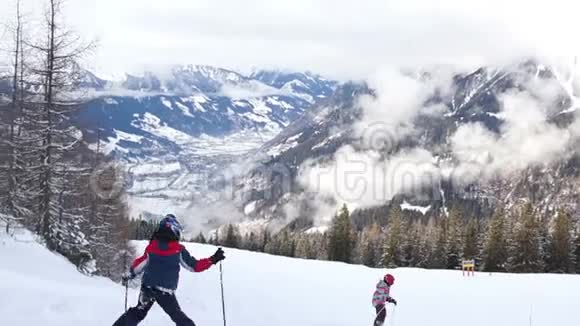 青少年穿着滑雪板下山山区家庭假日冬季运动滑雪美丽的山视频的预览图