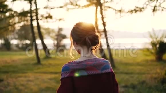 一个美丽的女人在夕阳下的秋天公园里欢快地散步视频的预览图
