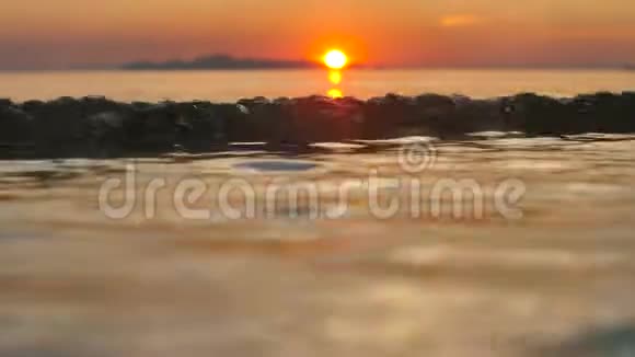 日落时间在平静的大海上热带海滩上的太阳越来越斜视频的预览图