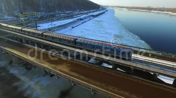 空中观景地铁列车在桥梁铁路上穿越冬季河流景观视频的预览图