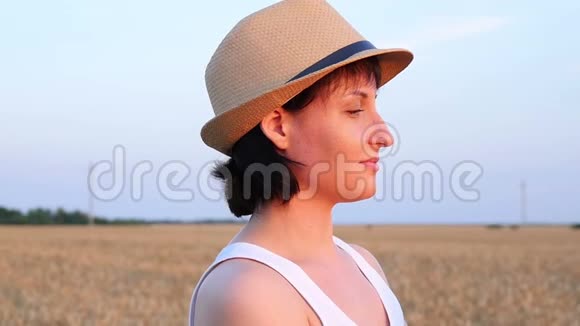 一个年轻的女人站在麦田里拿着面包把她的脸带来吸入香气农业视频的预览图