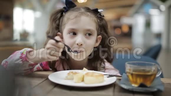 那个小女孩在机场的一家小咖啡馆里吃早餐喝绿茶视频的预览图