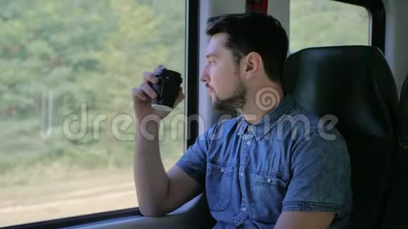 白人坐火车旅行喝着纸杯里的咖啡他一个人慢动作关闭视频的预览图
