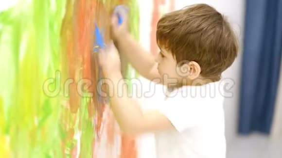 和妈妈一起在白色的墙上做彩色的手印把快乐的小孩子合上慢动作视频的预览图
