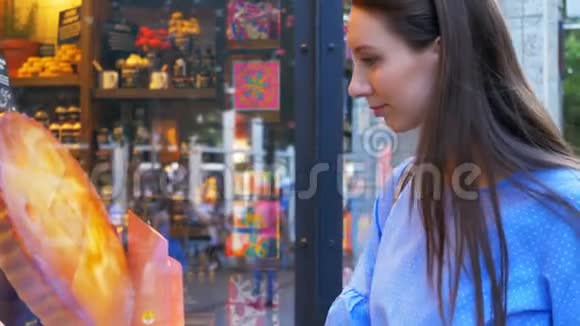 年轻开朗的女人在商店橱窗里看化妆品和身体护理产品视频的预览图