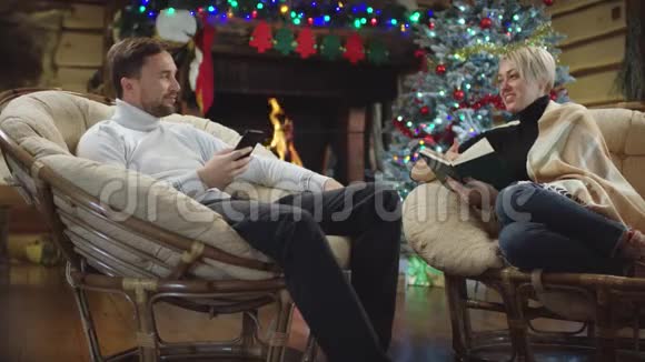 在圣诞节的晚上丈夫和妻子一边看书一边上网视频的预览图