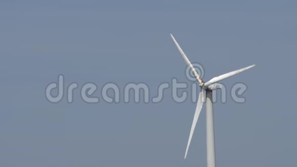 慢运动风力涡轮机叶片在蓝天上旋转视频的预览图