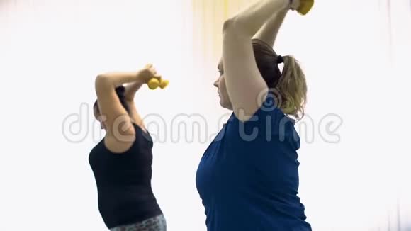 胖女人在健身房用哑铃锻炼视频的预览图