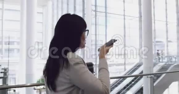 女商人在4k办公室的大厅里用手机交谈视频的预览图