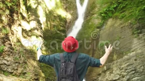 冰岛瀑布前男子举着手后摄视频的预览图