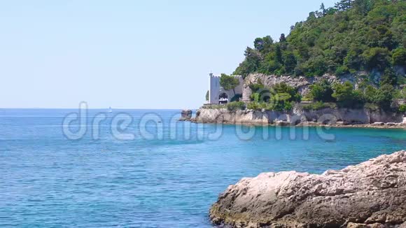 岩石山上有一座城堡在蓝色的海水之上在遥远的地区有一座城堡坐落在被开槽的山上视频的预览图