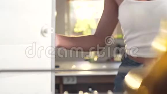 女人拿着大布列斯特打开冰箱搜索里面的食物从冰箱里看就像女人打开一样视频的预览图