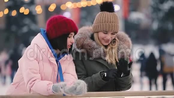 快乐的女性朋友在冰场上聊天慢动作视频的预览图